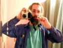Holding a camera in one hand and toothbrush in my mouth in the other as seen in a mirror