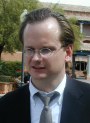 Lessig with wireframe glasses and loose tie