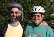 Two guys smiling wearing bike helmets